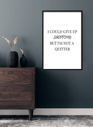 Give up shopping poster on a dark wall, above a wooden dresser with vases and dried plants.