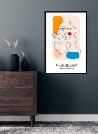 Picasso inspired Portrait imaginaires poster with abstract face and colorful shapes, framed on a dark wall above a dresser.