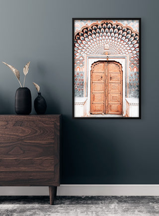 Framed print of an ornate wooden door in Marrakech, displayed above a dresser in a modern room.