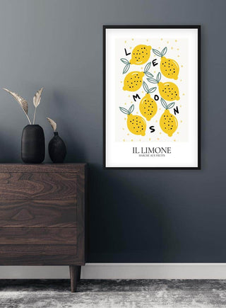 Framed Il Limone fruit poster with illustrated yellow lemons hanging on a dark wall above a wooden dresser.