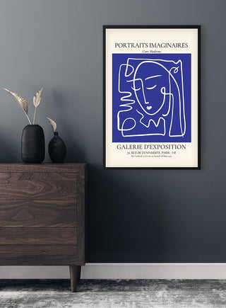 Framed Portraits Imaginaires Blue No. 2 Plakat hanging on a dark wall above a wooden dresser with vases.