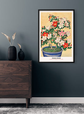 Framed Ohara Koson - Blooming Azalea Plakat print hanging on a dark wall above a wooden dresser.