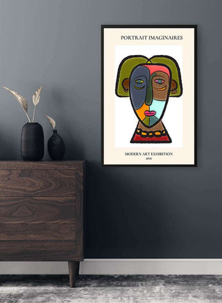Framed Portrait Imaginaires Colors Plakat featuring a colorful abstract face hangs on a dark gray wall above a dresser.