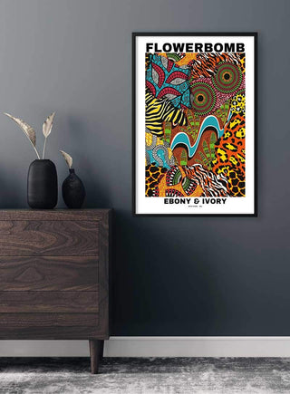 Flowerbomb Ebony & Ivory Plakat poster with vibrant animal and floral patterns hanging on a gray wall above a dresser.
