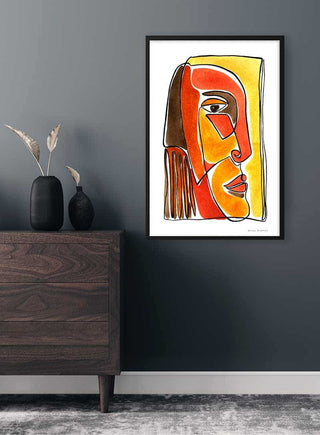 Framed Yellow and Red Face Imaginaires Plakat artwork displayed on a dark wall above a wooden dresser.