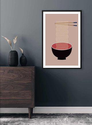 Minimalist poster of a black bowl with ramen noodles and chopsticks, displayed on a dark wall above a dresser.
