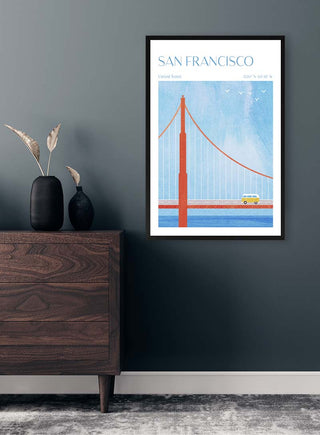 Framed San Francisco - Henry Rivers poster featuring the Golden Gate Bridge, displayed above a dark wood dresser.