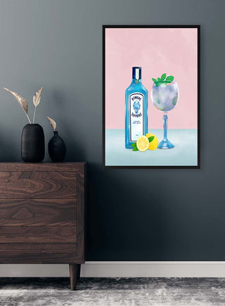 Framed artwork of a gin cocktail with garnish, lemon, and tonic bottle hanging on a stylish wall.