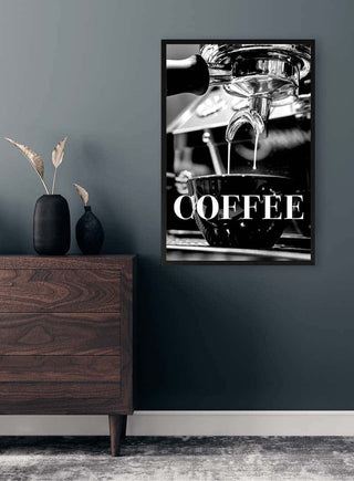 Black-and-white wall art of espresso pouring into a cup with "COFFEE" text, displayed above modern furniture.