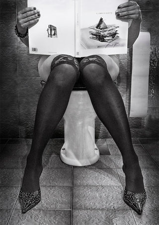 Person in stockings and heels seated on a toilet, reading "Le GoArt des autres" by Giorgio Toniolo.