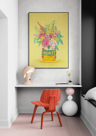 Colorful flowers arranged in a vintage honey can, artwork by Raissa Oltmanns displayed above a modern desk.