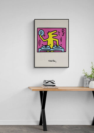 Framed DJ - Keith Haring artwork featuring a yellow figure mixing on turntables, displayed above a modern console table.