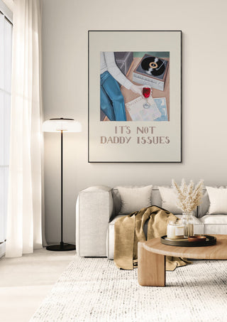 Framed Daddy Issues - Christine Buchholtz poster above a modern sofa in a cozy, minimalist living room.