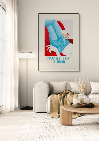 Framed "Fragile - Christine Buchholtz" artwork displayed in a modern living room above a light sofa.