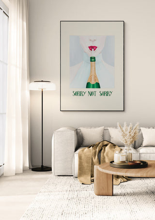 Framed "Not Sorry" art print by Christine Buchholtz displayed above a sofa in a modern living room.