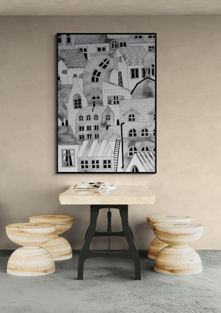 "Compact City" by Hedwig Wallin artwork hangs above a modern wood table with three stools in a minimalist room.