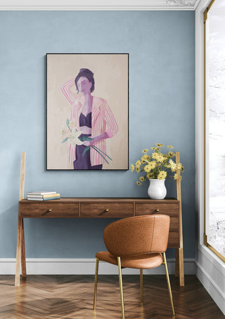 Framed "Lilly in a Jacket - Goed Blauw" artwork on a blue wall above a wooden desk with flowers.