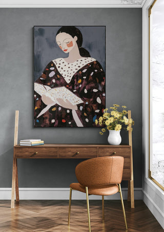 Framed art of a woman reading on a wall above a wooden desk, promoting Books of My Life by David Wolf.