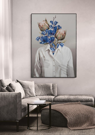 Large painting of a headless figure in a white shirt with flowers for a head, hanging above a modern sofa.