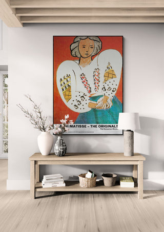 Framed "The Romanian Blouse - Henri Matisse" artwork above a wooden console table in a modern living room.