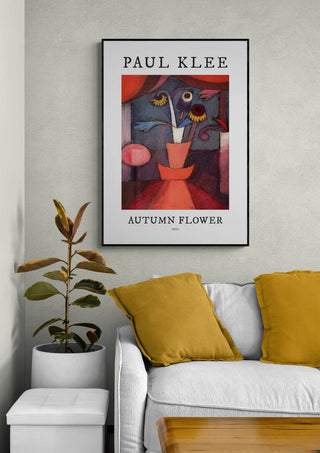Framed "Autumn Flower 1922" by Paul Klee hanging above a white sofa with yellow cushions.