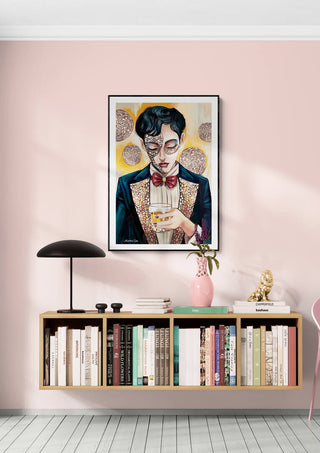 Framed "Two - Martin Zen" artwork above a bookshelf with books, lamp, and decor against a pale pink wall.