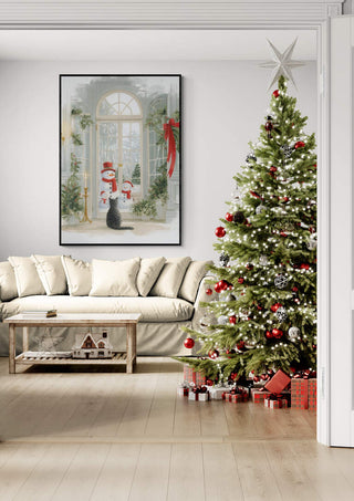 Framed Snowfamily artwork on wall beside decorated Christmas tree, shown in cozy living room setting.
