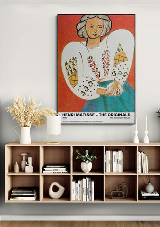 Poster of "The Romanian Blouse" by Henri Matisse displayed above a modern wooden shelf with books and decor.