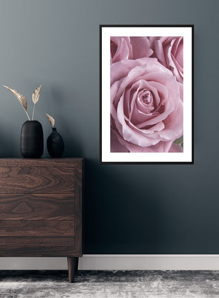 Pink Single Rose poster framed on a dark wall above a wooden dresser with decorative vases.