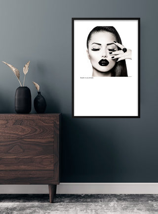 Modern room with a "Beauty is an attitude" fashion poster featuring a stylish woman with bold makeup.
