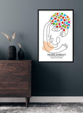 Picasso-inspired abstract portrait poster with colorful dots displayed above a modern wooden dresser.