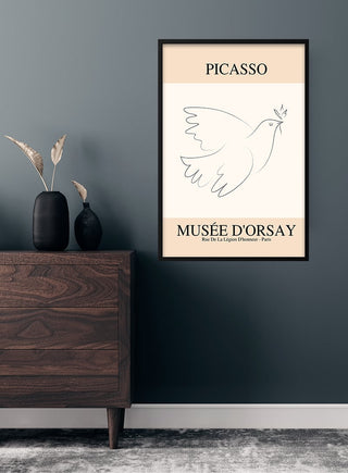 Minimalist Picasso Inspired Bird of Peace poster framed on a dark wall above a wooden dresser with vases.