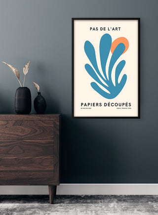 Pas De L'art Blå og Orange Plakat showing abstract blue and orange shapes, framed on a dark wall above a dresser.