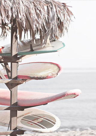 Four surfboards stacked under a thatched roof by the beach, displayed on Surfboards on Beach Plakat.