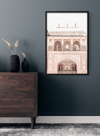 Framed poster of an ornate old Indian building displayed above a wooden dresser in a modern room.