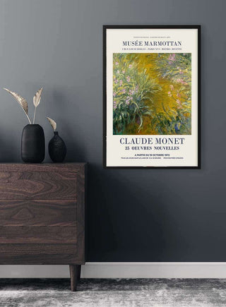Framed print of Monet’s "The Path through the Irises" displayed above a modern wooden dresser.