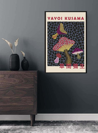Framed Yayoi Kusama Red Mushroom Plakat on a dark wall above a wooden cabinet with decorative vases.