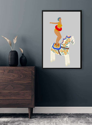 Framed artwork of a woman in red standing on a decorative white pony, displayed above a wooden dresser.