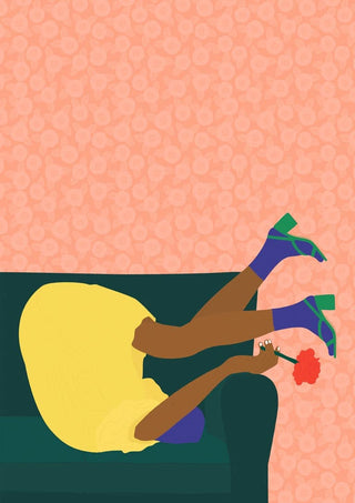 Person in a yellow dress holding a red flower, playfully posing upside down on a sofa for New Year's Eve.