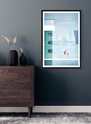 Framed Copenhagen Henry Rivers poster featuring a cyclist, displayed on a dark wall above a wooden dresser.
