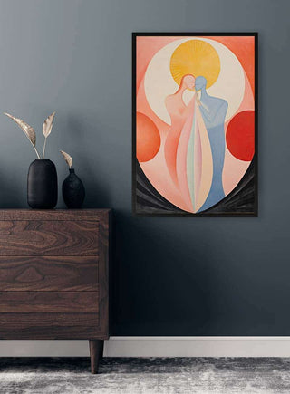 Framed print of "The Kiss No 02" by David Wolf hanging above a wooden chest in a modern room.