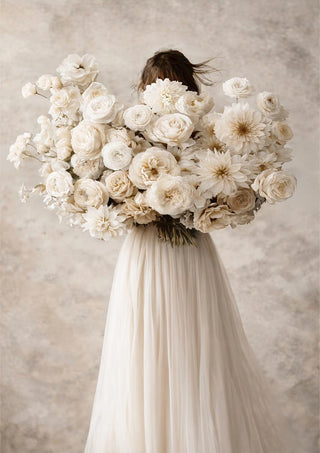 Woman in a flowing dress holding large bouquet of white flowers, Floralia by Annika Persson.