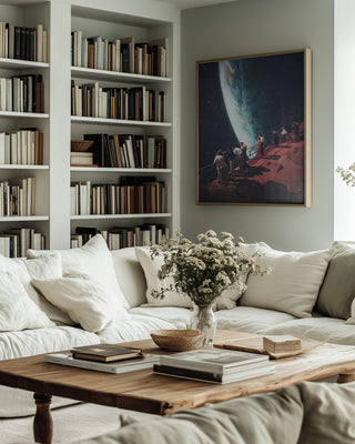 Framed "Missing the Ones We Left Behind" by Frank Moth hanging in a cozy living room with bookshelves and sofas.