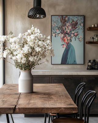 Framed "I Was Hidden but You Saw Me" by Frank Moth hangs in a modern dining room with flowers on the table.
