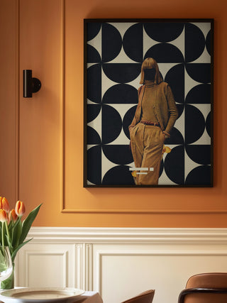 Framed 1978 Annie Collection artwork by Frank Moth on a warm-toned wall above a table with orange tulips.