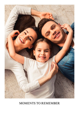 Smiling family of three lying together, featured on a customizable Image Upload Poster with "Moments to Remember" text.