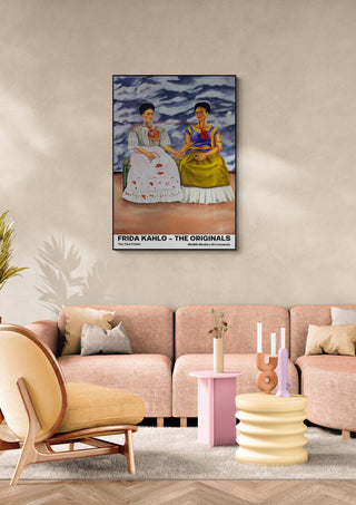 The Two Fridas by Frida Kahlo art print displayed above a modern beige sofa in a stylish living room.