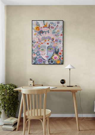 The Tribe - Vincent V. artwork featuring a colorful abstract face with floral and nature elements, hanging above a desk.