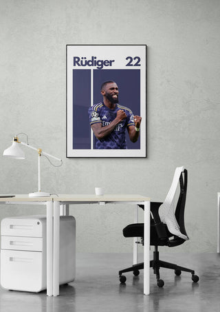 Antonio Rüdiger football poster on wall above modern office desk, featuring his name and number 22.