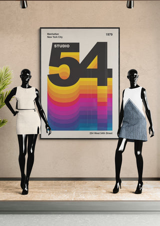 Two mannequins in retro dresses stand by a colorful Studio 54 poster on display.